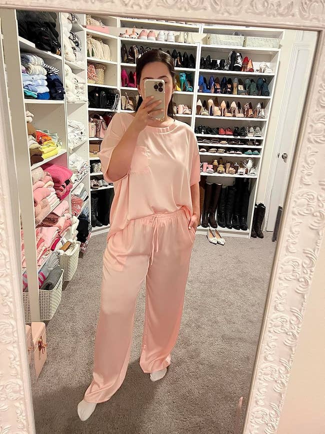 A reviewer taking a reflector selfie wearing silk pajamas
