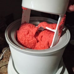 Ice cream maker with red sorbet being churned