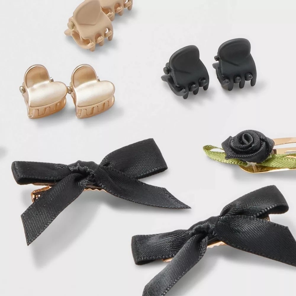Various black and gold hair clips, including heart shapes and bows, displayed on a light background