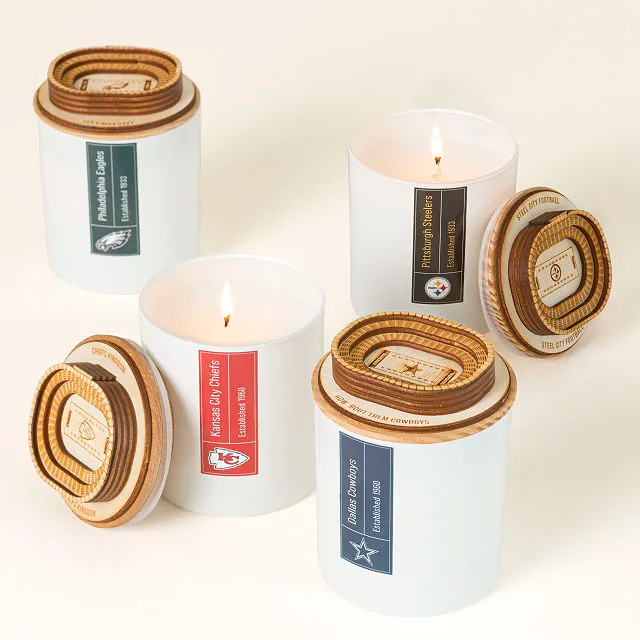 Four scented candles in white jars, each with a different NFL team logo: Philadelphia Eagles, Kansas City Chiefs, Pittsburgh Steelers, Dallas Cowboys