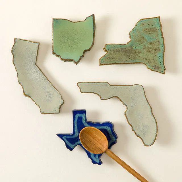 Ceramic plates shaped like US states—California, Texas, Florida, Ohio, New York—displayed with a wooden spoon