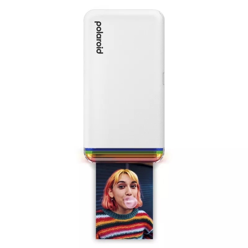 Polaroid printer printing a photo of a person blowing bubble gum, wearing a striped sweater