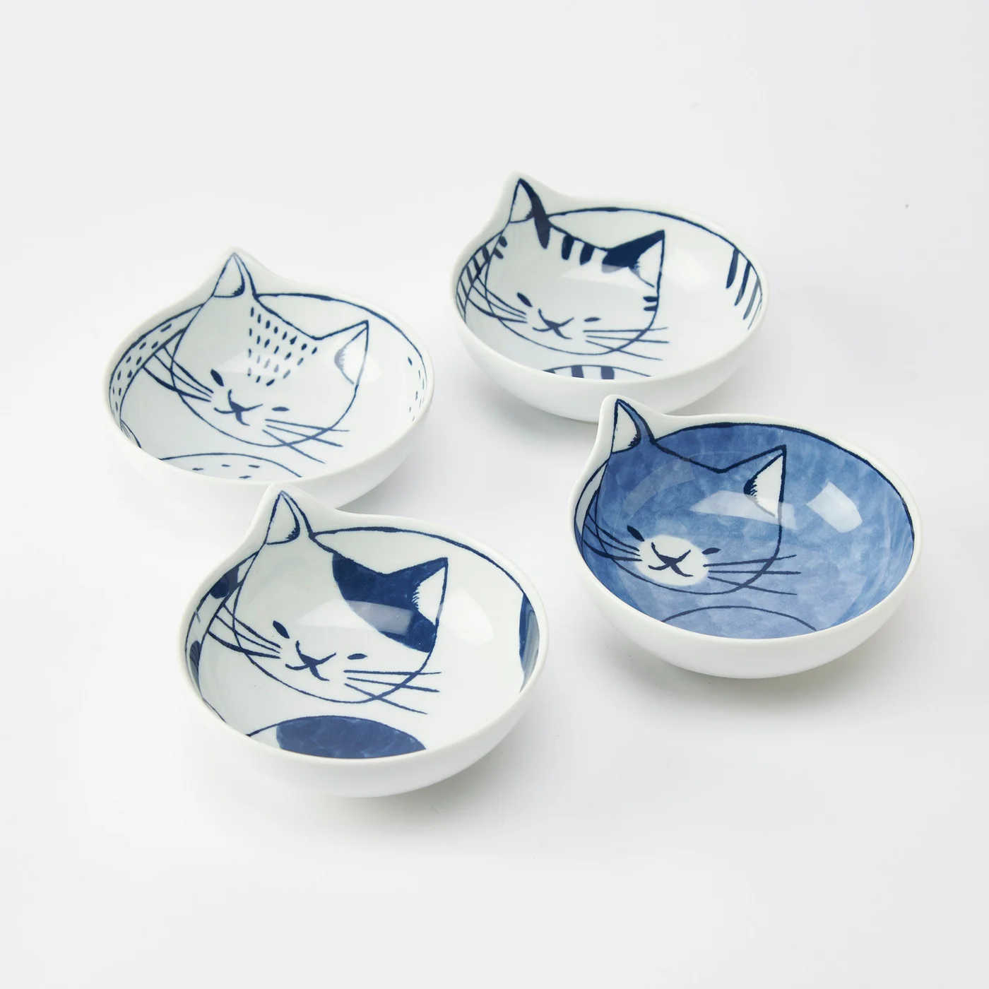 Four ceramic bowls with cat face designs