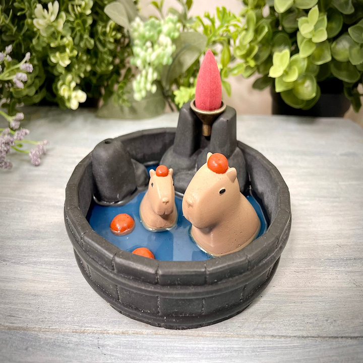 incense burner shaped like a mini stone pool with capybara figurines relaxing with oranges