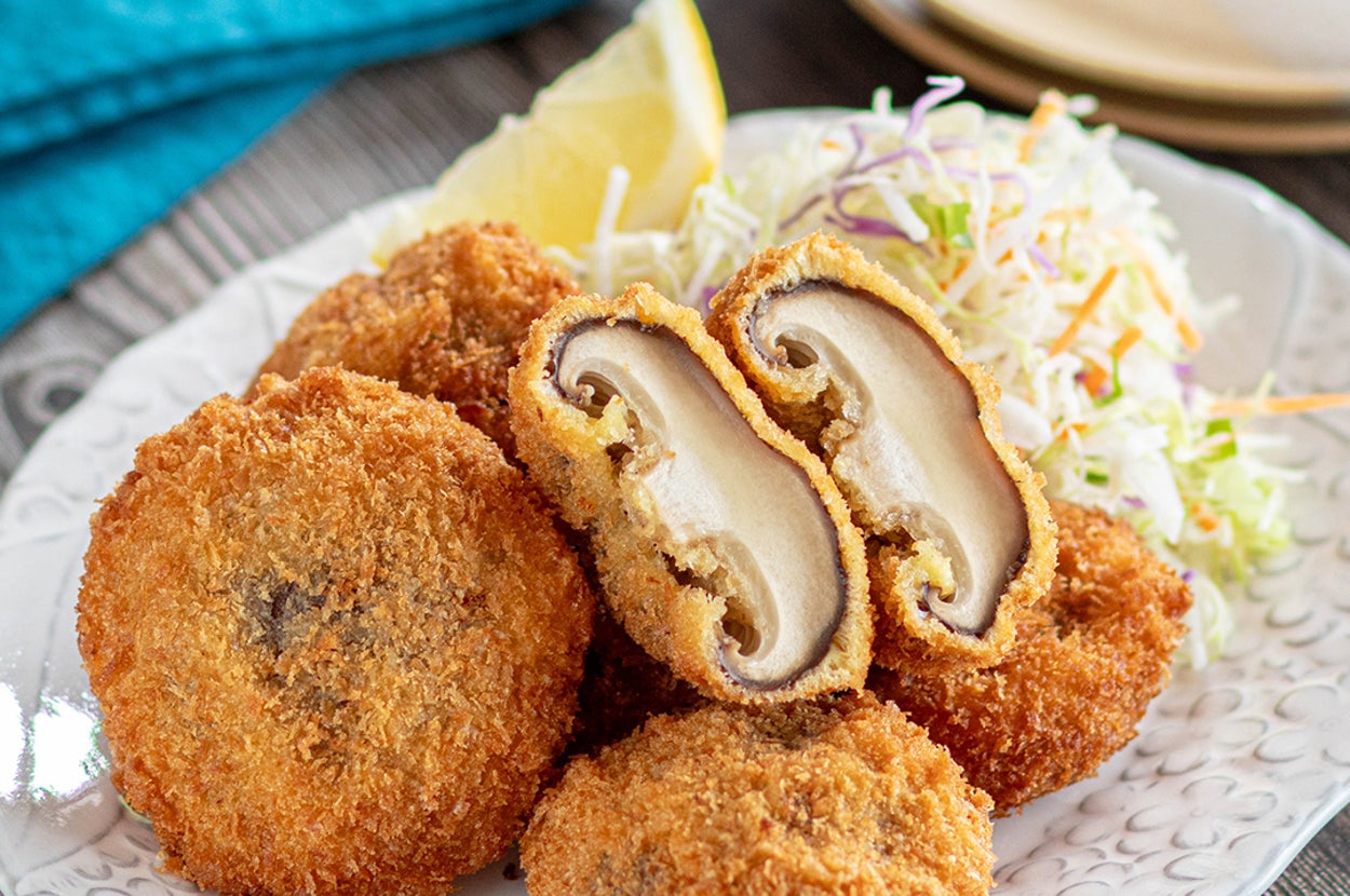 お皿に盛られたフライドしいたけと千切りキャベツ、レモンが添えられた料理。
