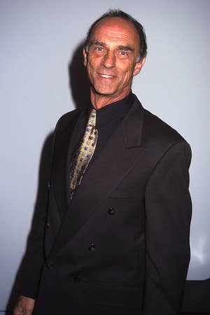 Marc in a double-breasted suit with a patterned tie, smiling towards the camera