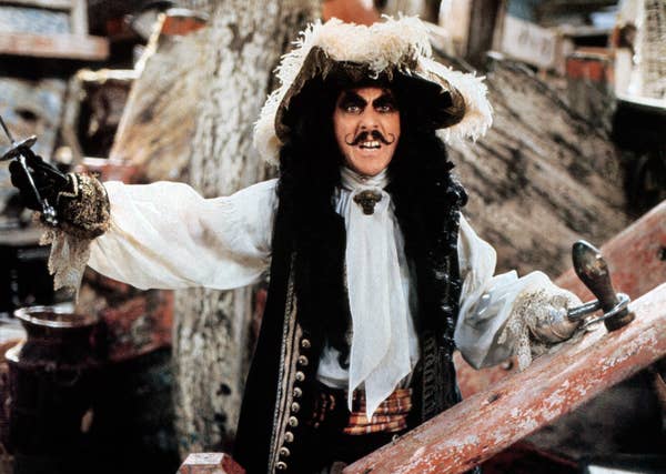 Dustin dressed as a pirate with lavish hat and coat, striking a dramatic pose on a wooden staircase