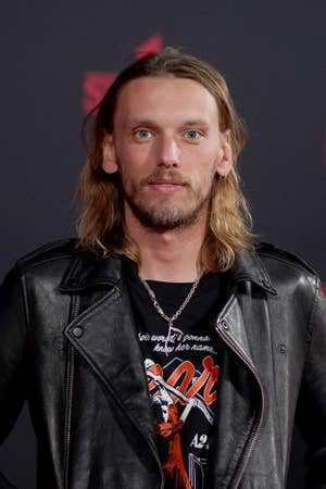 Jamie leather jacket and graphic tee poses on a red carpet, showing casual rock-inspired style