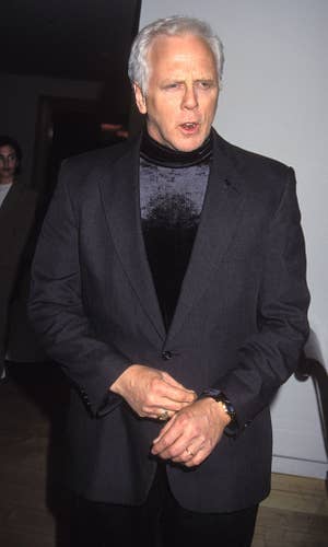 Hertzler in a dark suit with a velvet turtleneck at a formal event