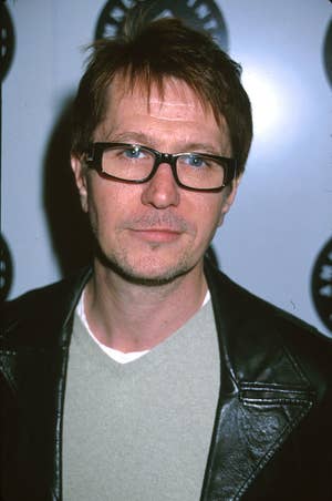 Gary wearing glasses and a dark leather jacket attends a media event