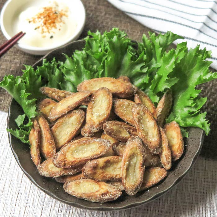 ゴボウの揚げ物がレタスと一緒に盛られた美しいプレート。背景にマヨネーズが見える。