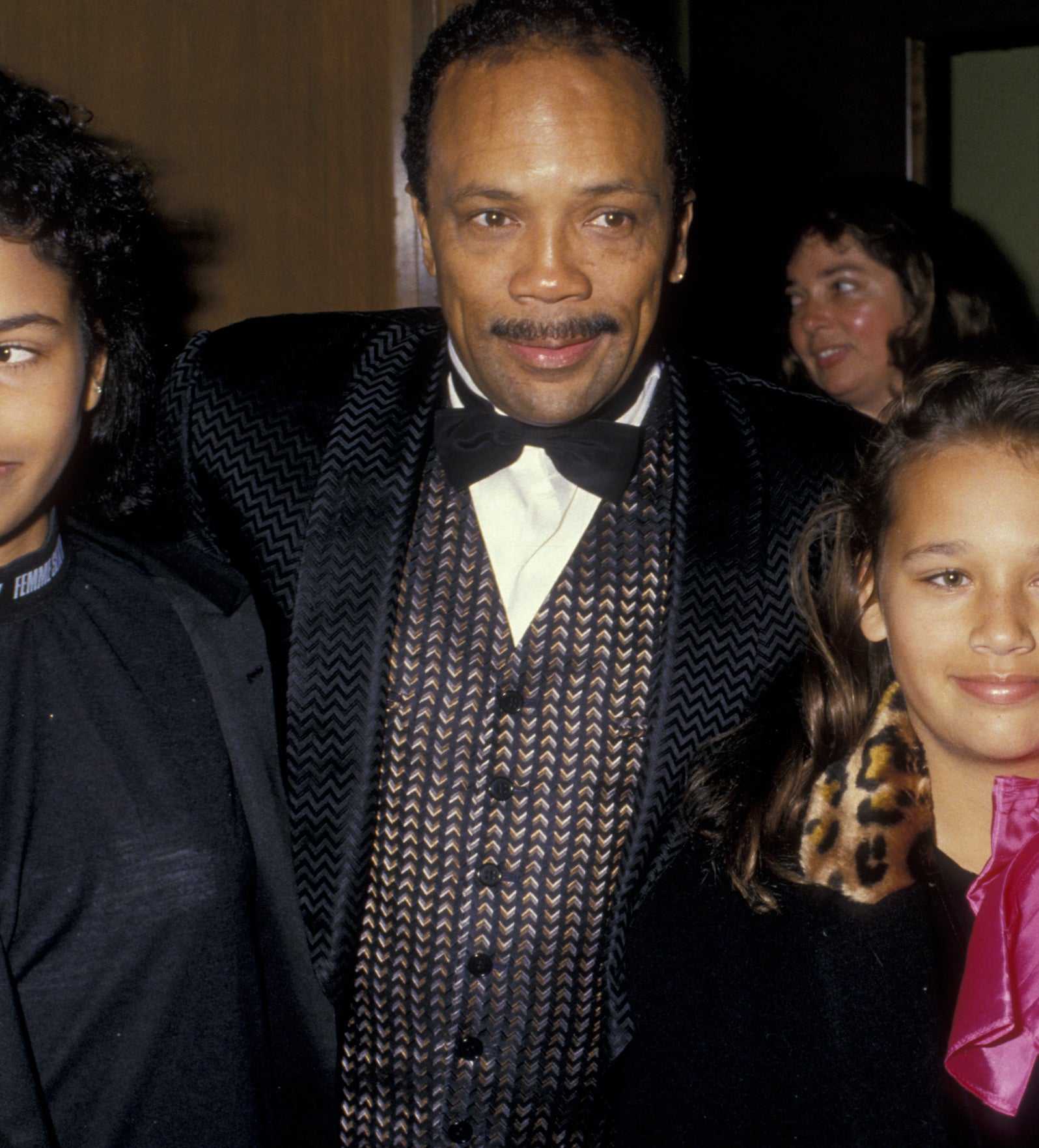 Quincy Jones in a tuxedo with his arm around young Rashida Jones who is wearing a coat with a pink scarf