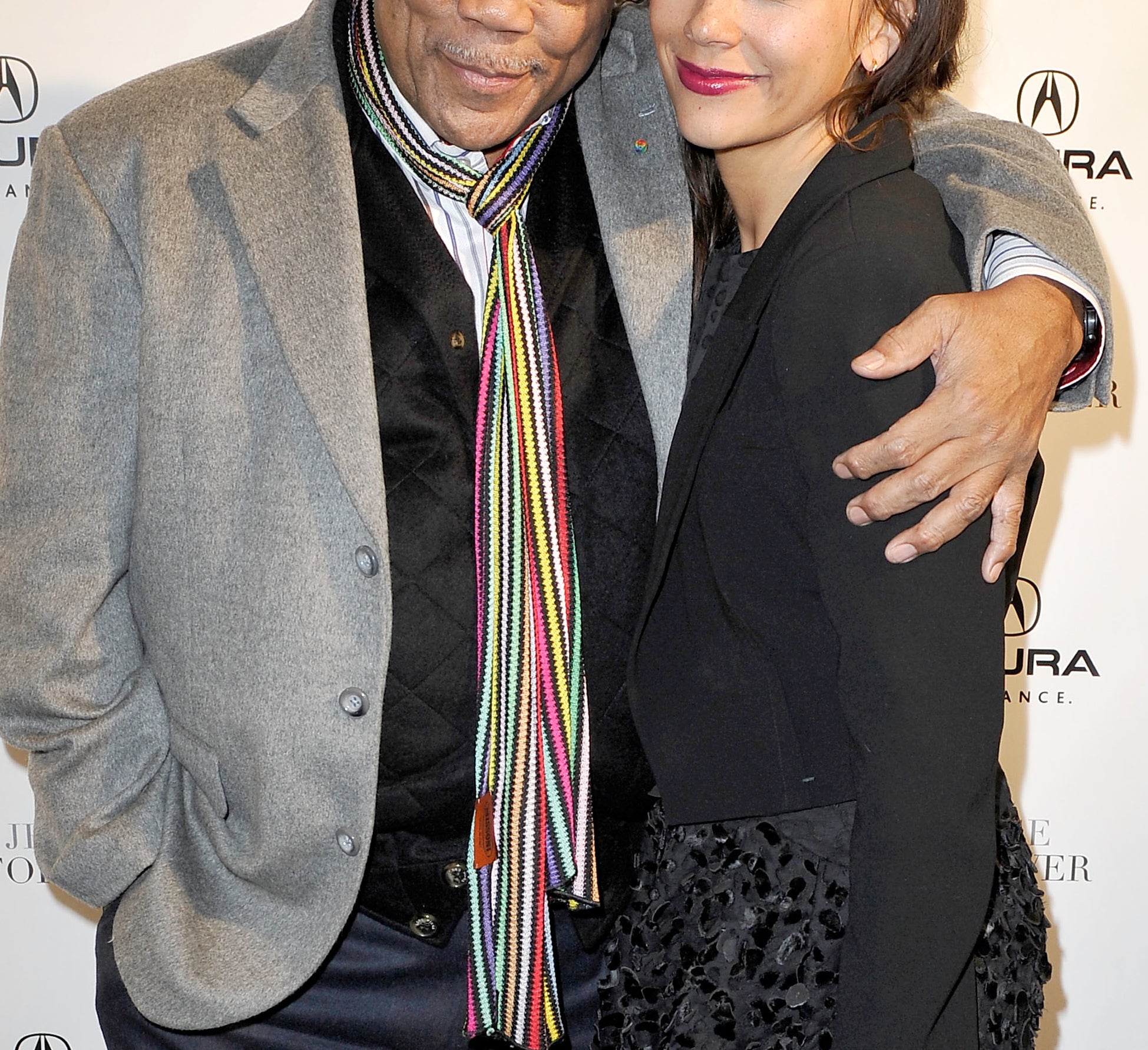 Quincy Jones in a blazer and colorful scarf with Rashida Jones in dark outfit posing at an event backdrop featuring Acura and "Jesse &amp;amp; Forever."