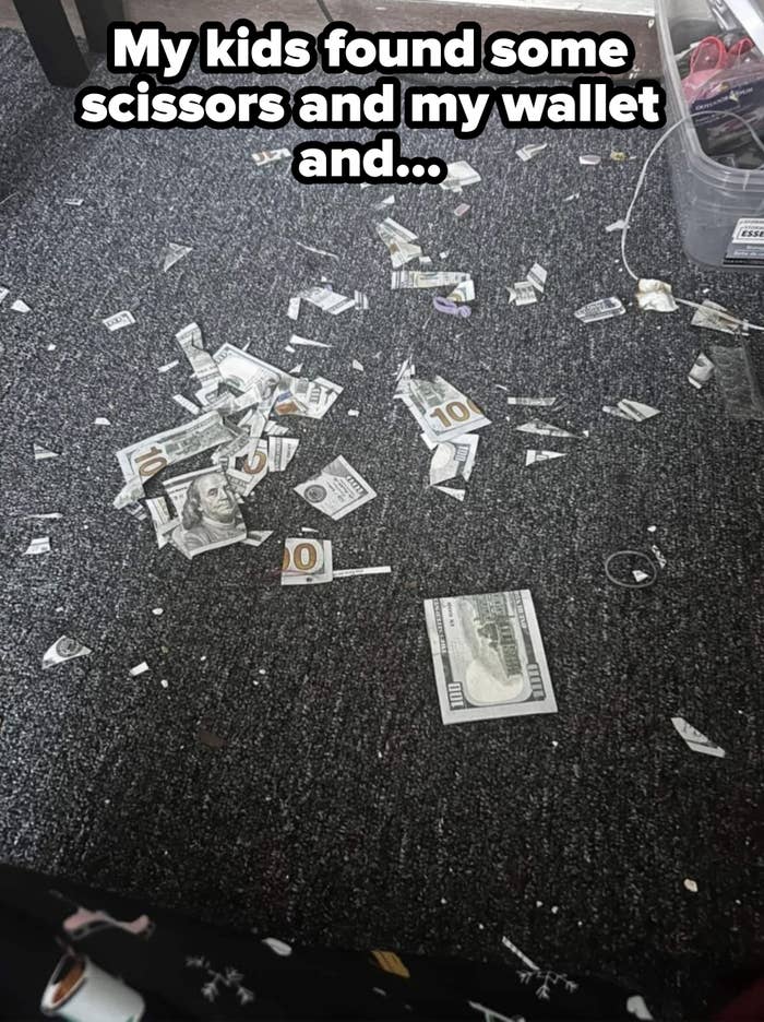 Shredded paper resembling money scattered on a carpeted floor next to a plastic box with cords