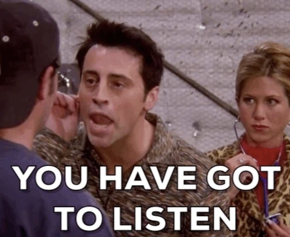 Man pointing at another's ear, with text: "YOU HAVE GOT TO LISTEN", while a woman stands in the background