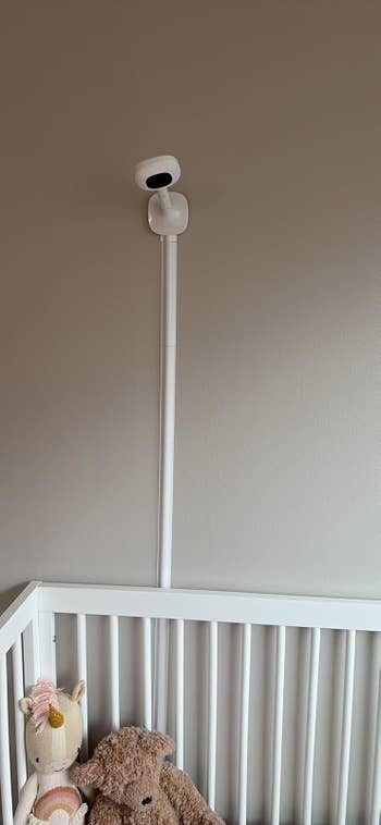 Baby show mounted connected partition supra a crib with a stuffed unicorn and teddy bear. Ideal for nursery buying article