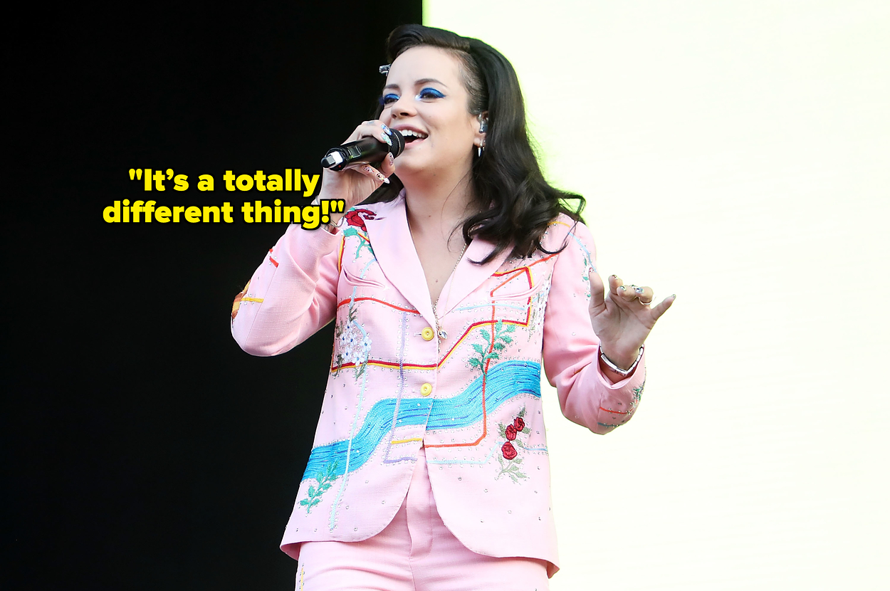 Lily Allen singing on stage in a floral suit with a microphone in hand