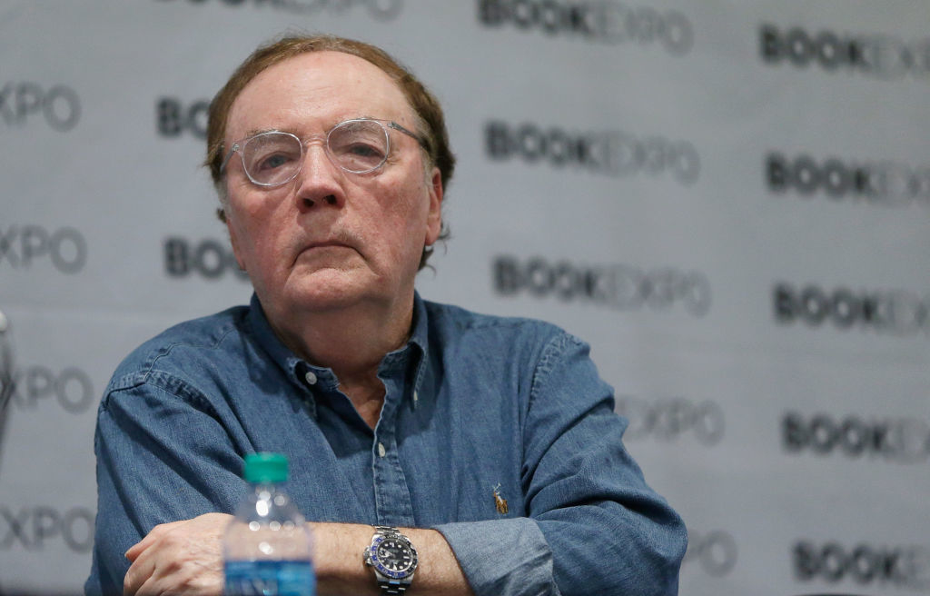 A person in a denim shirt sits at a book event. The background features a repeated "BookExpo" logo
