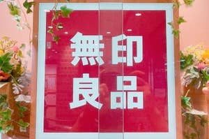 「無印良品」の看板。周囲に花の装飾が施されています。