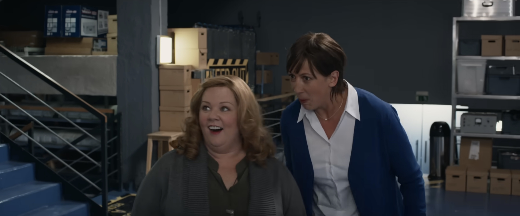 Melissa McCarthy and another woman look on at a spy training facility in awe