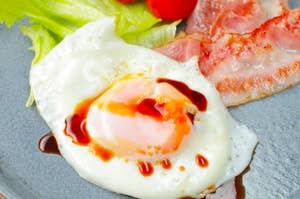 目玉焼き、ベーコン、レタス、トマトが盛り付けられた朝食の一皿。