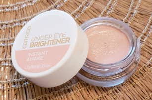 Catrice Under Eye Brightener container on a woven surface
