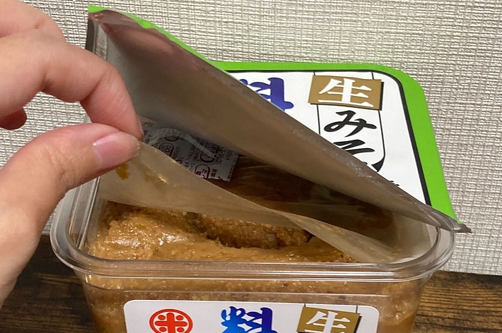 手で開封される減塩味噌のパッケージ。