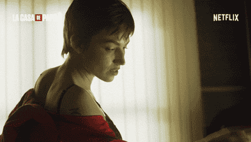 Person with short hair looks down thoughtfully, wearing a sleeveless top. Text: &quot;La Casa de Papel,&quot; &quot;Netflix&quot; in corners