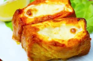 レモンと葉野菜と一緒に盛り付けられたグリルされたチーズのトースト。