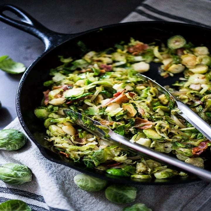 Sautéed Brussels sprouts and diced bacon in a cast iron skillet