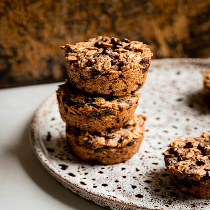Three stacked oat muffins with chocolate chips on a speckled ceramic plate