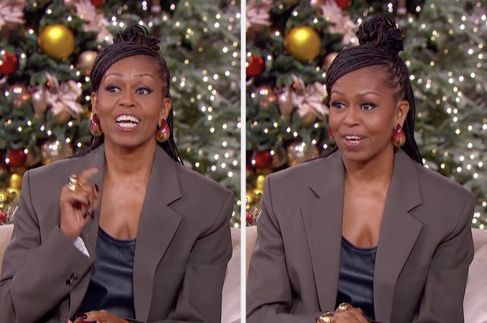 A person sits in front of a festive background, wearing a large blazer and earrings, likely in a holiday setting