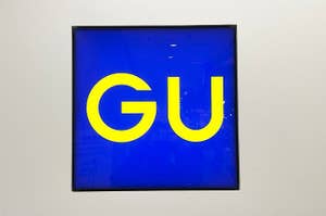 Storefront sign displaying the letters "GU" in bold, bright letters