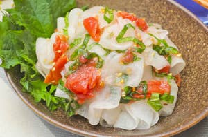 大根と梅肉の和え物が盛り付けられた陶器の器。食欲をそそる一品。