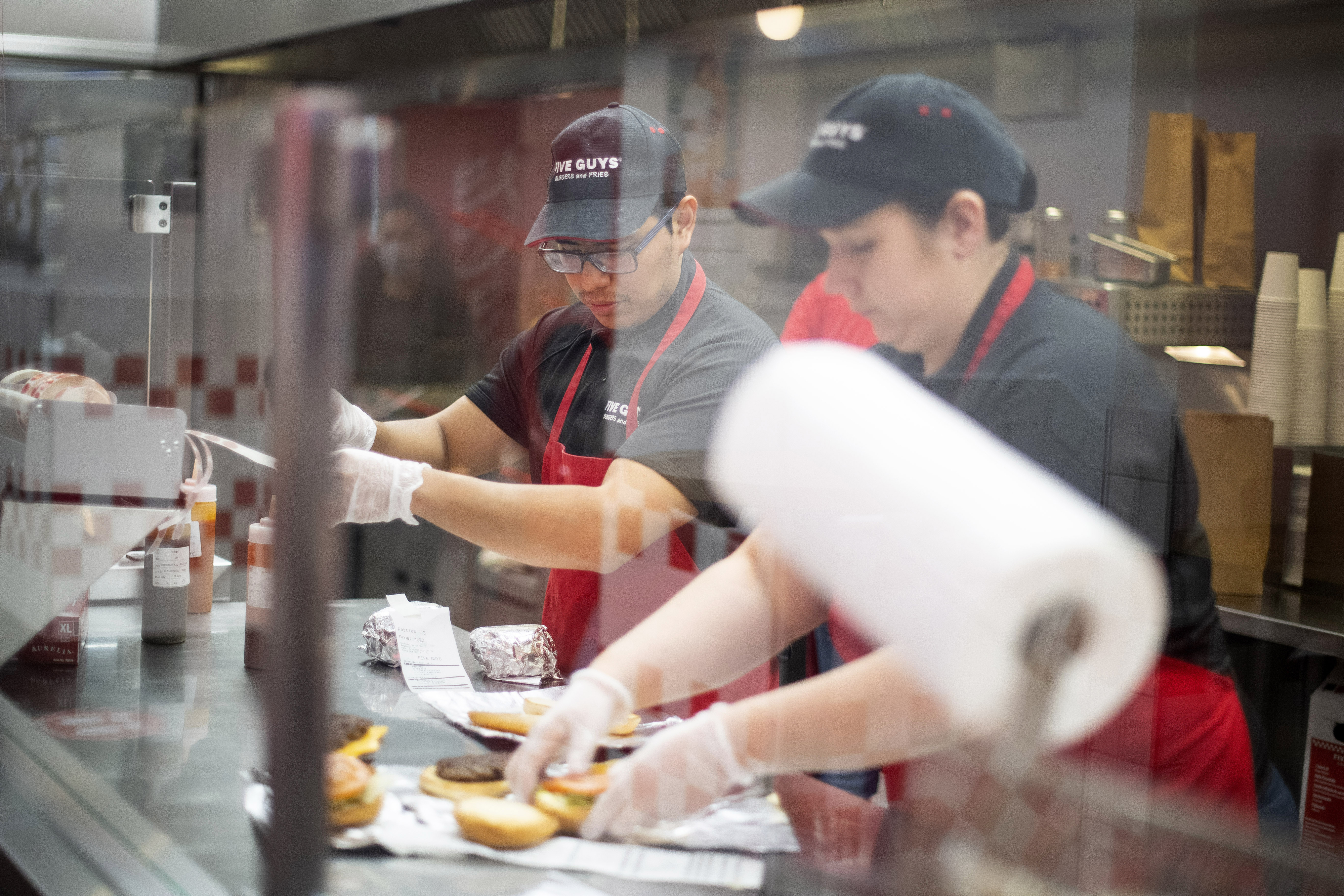 Five Guys employees assembling burgers.