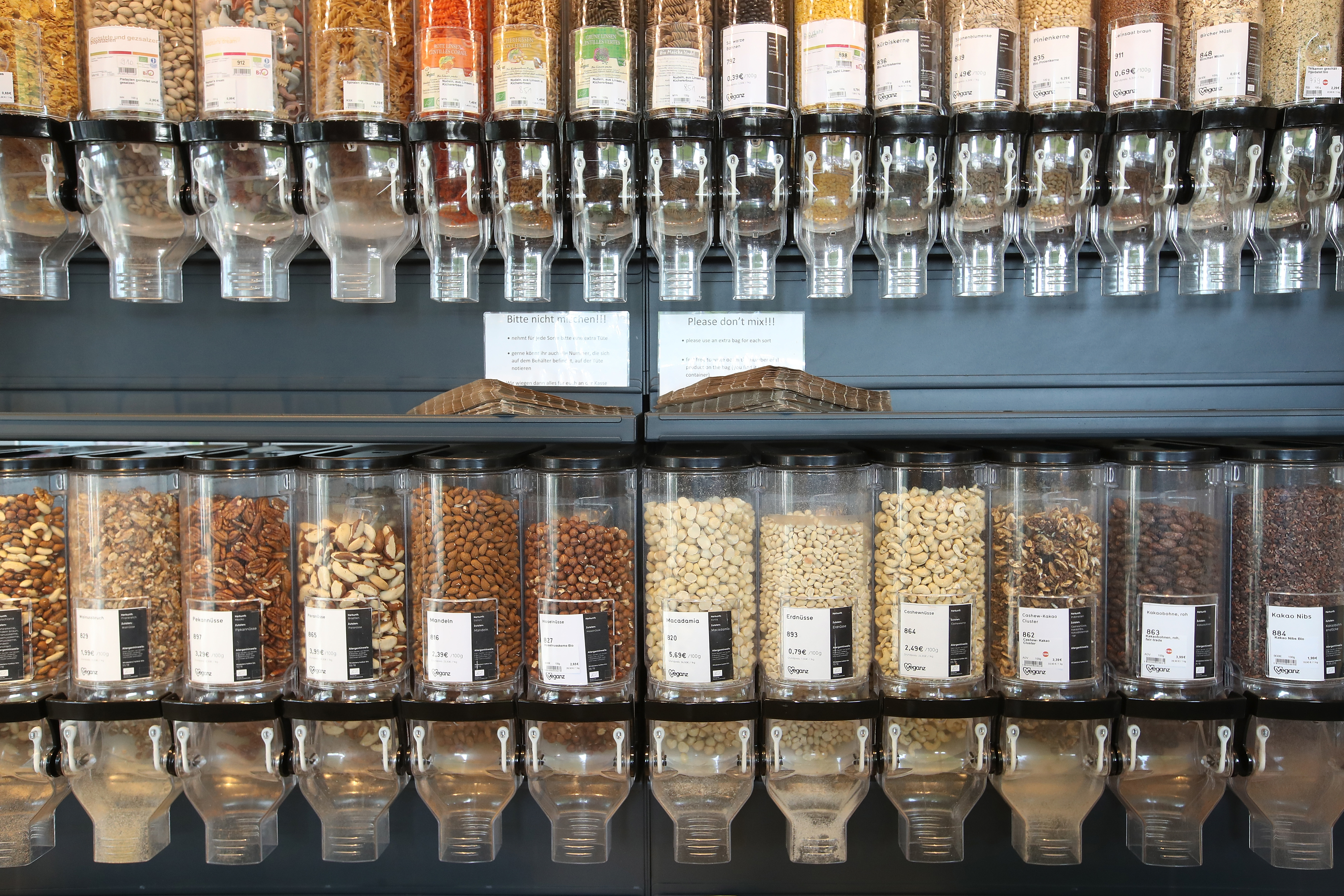 Rows of dispensers filled with assorted nuts and grains in a store