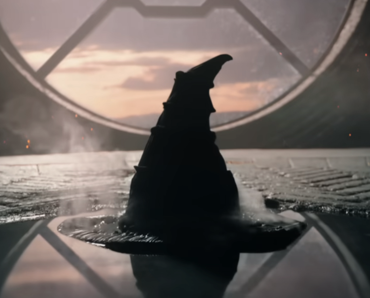 A mysterious, steam-emitting hat sits on a platform inside a room with a large circular window in the background