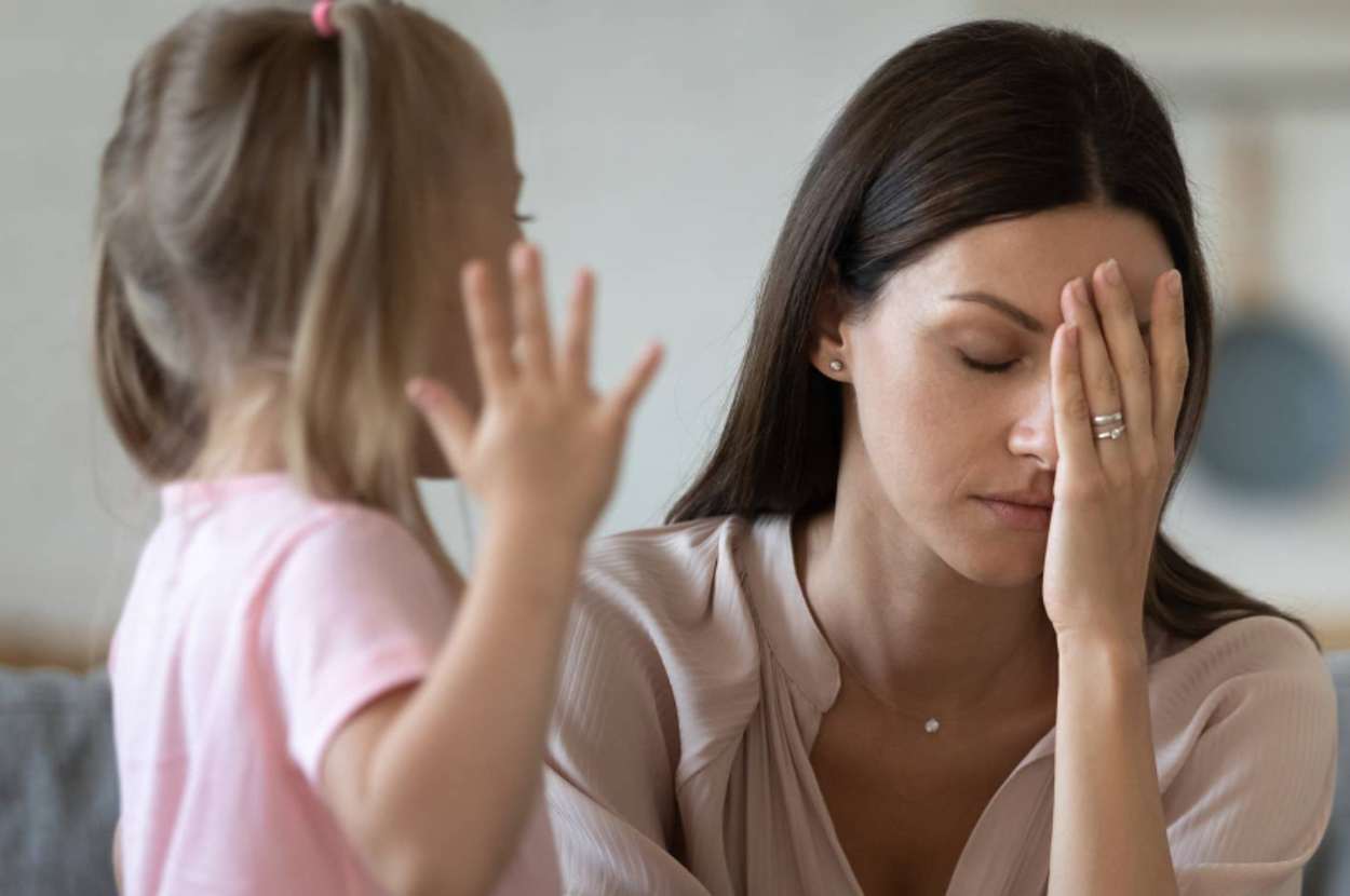 A woman looking stressed out by a kid