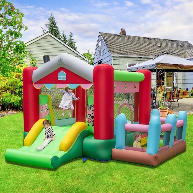 Kids playing on an inflatable bounce house in a backyard, featuring slides and colorful play areas