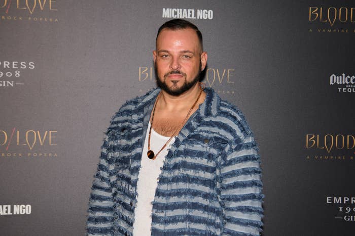 Person in a textured striped jacket at a &quot;Blood Love&quot; event backdrop
