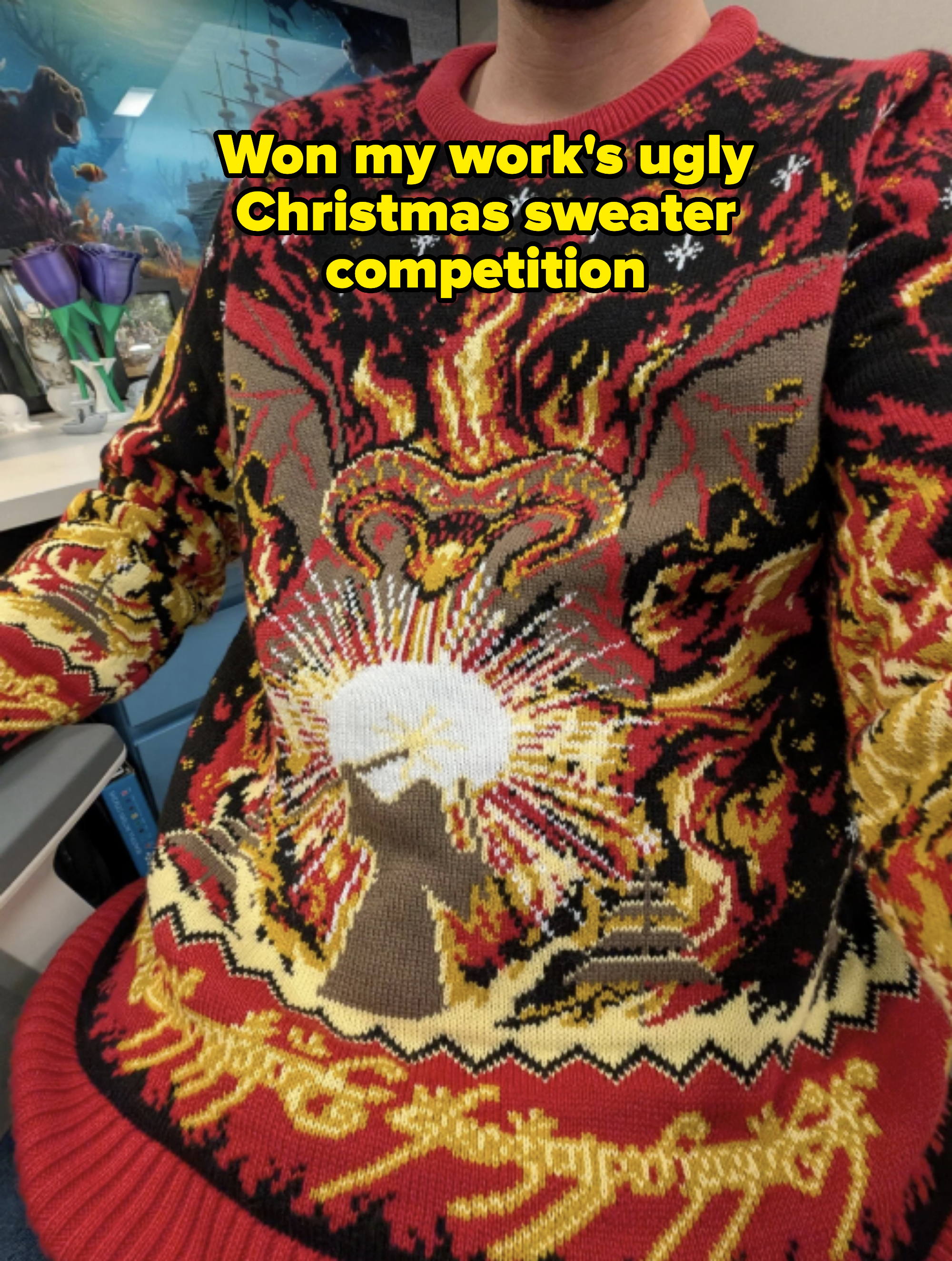 Person wearing a sweater with a bold, intricate flame and sunburst design, sitting indoors