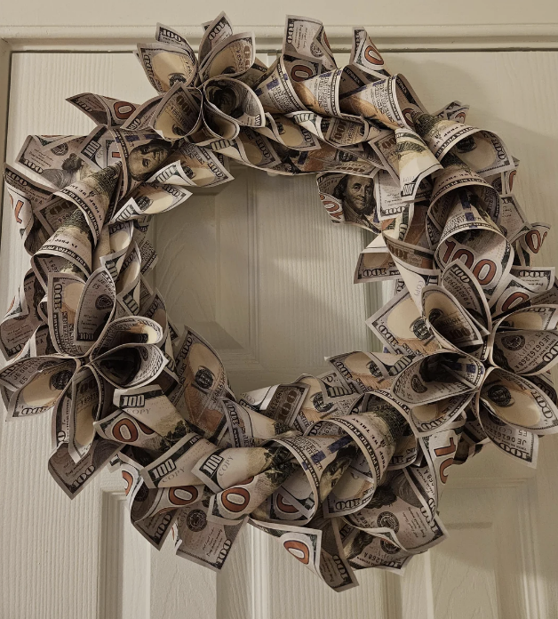 Wreath made of folded U.S. currency hangs on a door