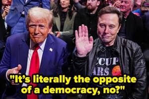Two people are seated together; one waves, wearing casual attire, the other in a suit. Text reads: "It's literally the opposite of a democracy, no?"
