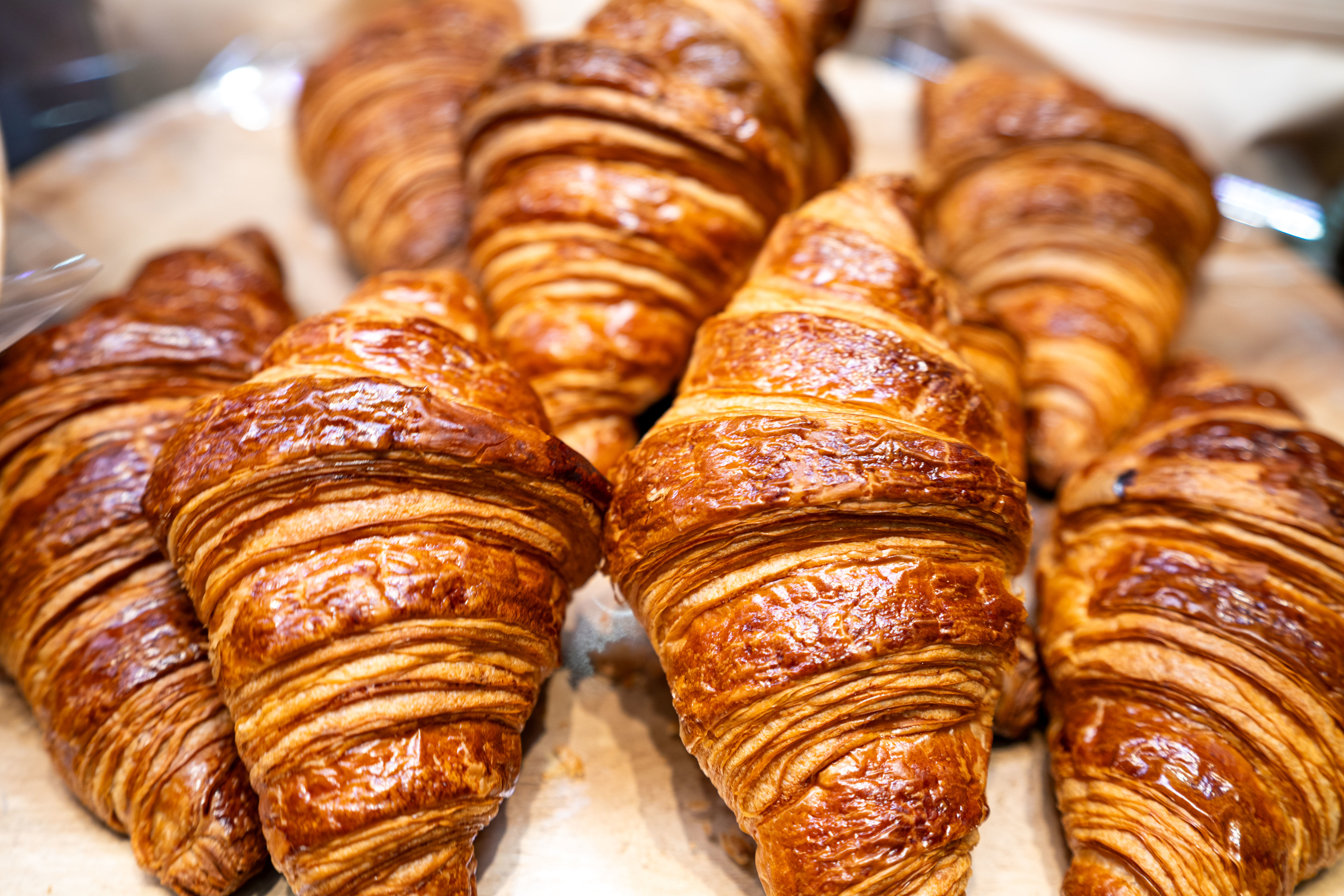 Freshly baked croissants arranged on a tray, highlighting their flaky, layered texture.