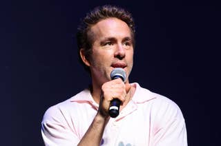 Ryan Reynolds speaking into a microphone on stage
