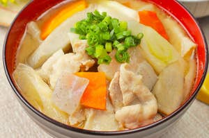 具だくさんの豚汁の写真。豚肉、にんじん、ごぼう、ネギ、こんにゃくが入っており、ご飯が添えられている。