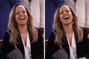 Person laughing joyfully, wearing a black blazer and white top, holding a handbag