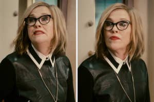 Moira Rose from "Schitt's Creek" wearing glasses and a leather-style top, sitting indoors, looking to the side with a neutral expression