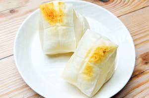 皿にのった焼いたもち二つ。木目のテーブルに置かれている。