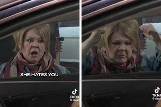 A person with a surprised expression gestures near a car window, where another person looks on with concern. They appear to be acting in a comedic scene